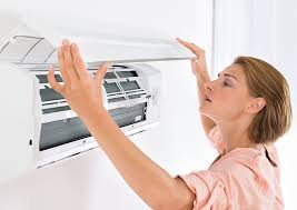 A women inspecting air filter of AC