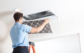 A man cleaning or replacing air filter of a/c
