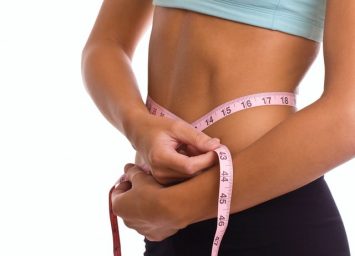 Woman measuring her waist on a weight loss program