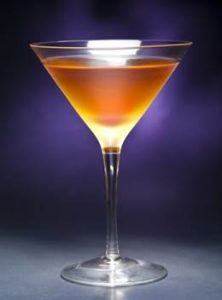 An Amber Martini in aMartini Glass with light shining on it.