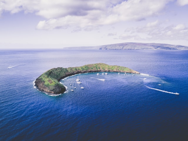 An aerial view of the Molokini crater and the ocean that's surrounding it.