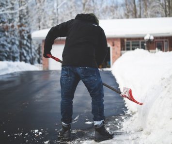 A man shoveling snow getting ready for professional mover