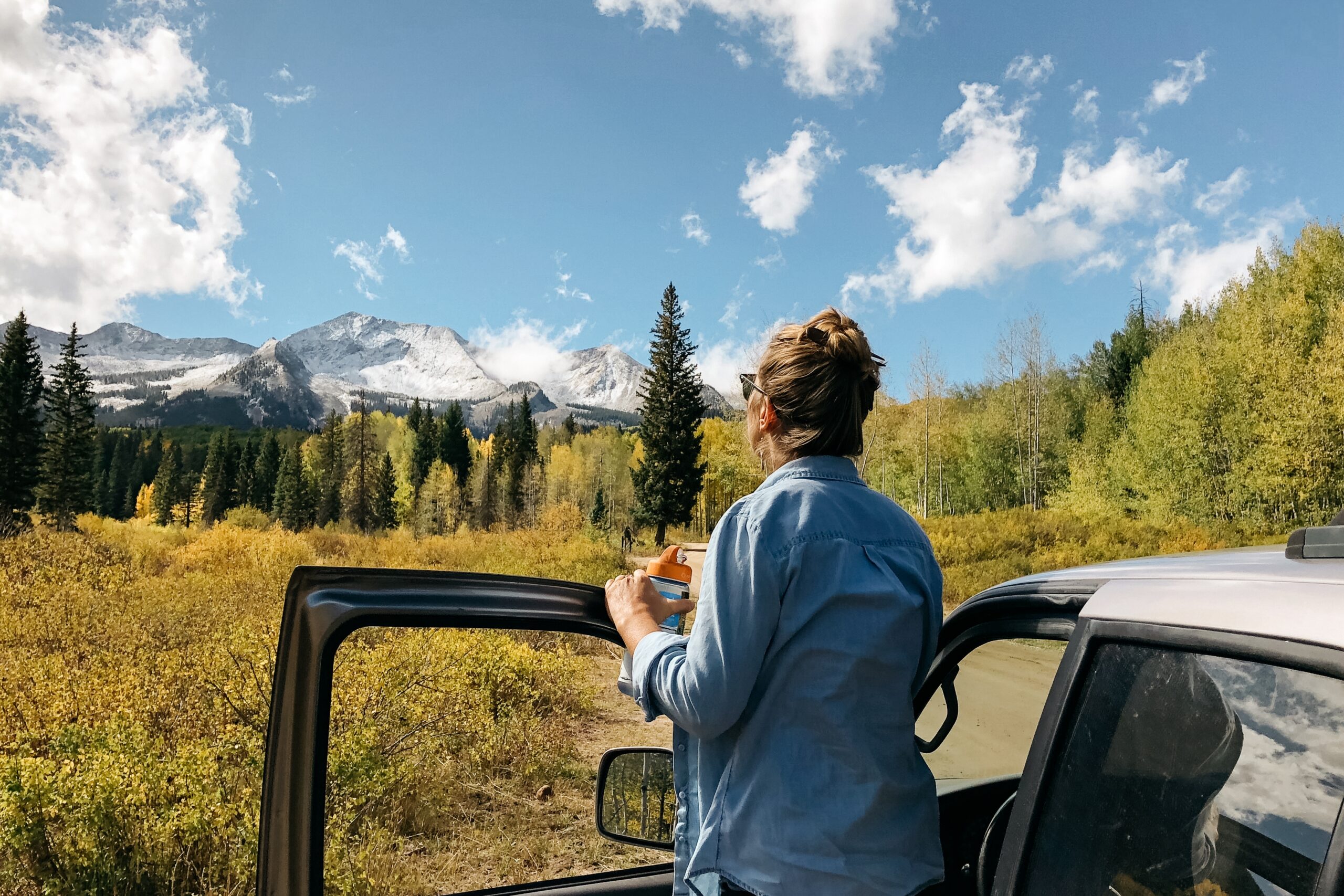 female-standing-near-car-enjoying-view