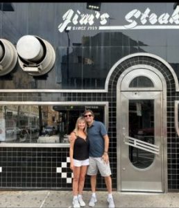 Two people standing in front of Jim's Steak in Philadelphia