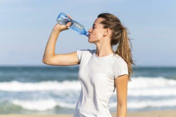 a woman drinking from a plastic bottle