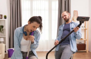 husband-wife-singing-together-while-cleaning-apartment