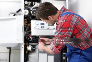 Technician servicing the gas boiler for hot water and heating