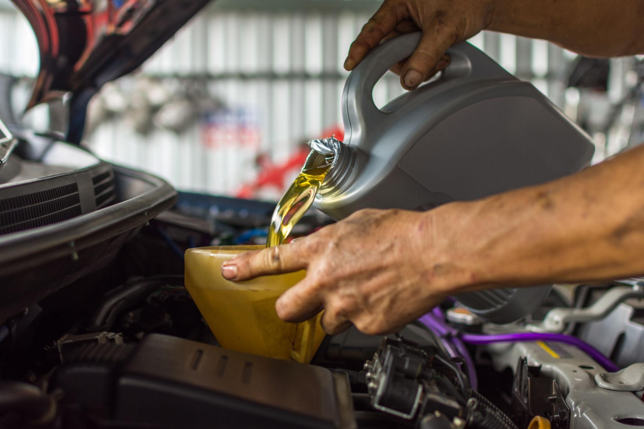 a man pouring Hydraulic Oil