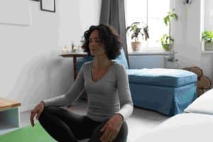 A woman sitting meditating finding happiness by looking inside of herself