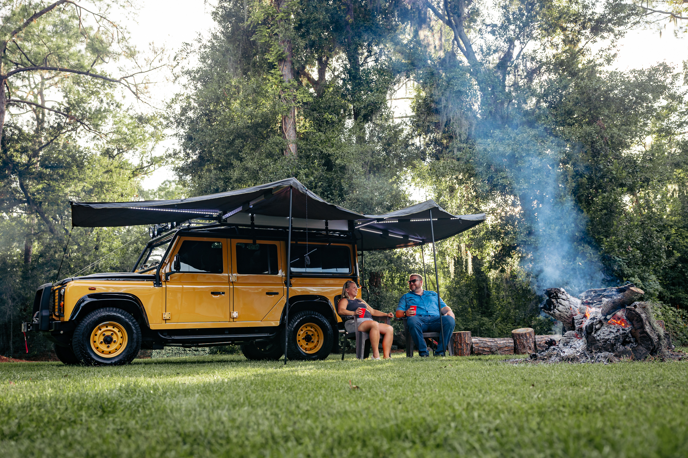 Family with bonfire and Land Rover Defender 110