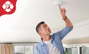 Guy checking smoke alarm